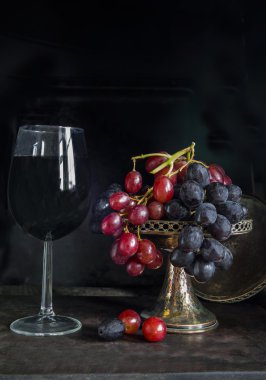 Kırmızı ve siyah üzüm ve bir kadeh kırmızı şarap