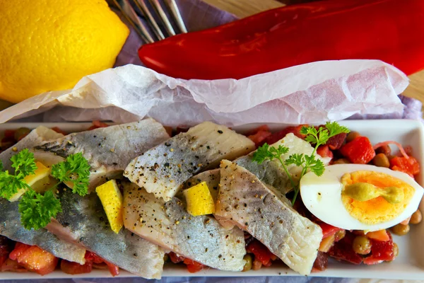 Arenque salgado com salada na mesa . — Fotografia de Stock