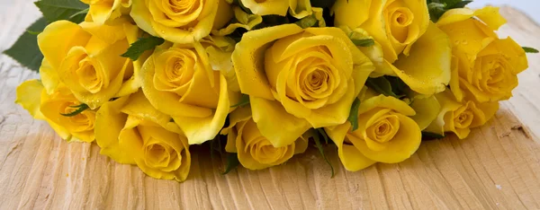 Rosas amarelas sobre mesa de madeira . — Fotografia de Stock