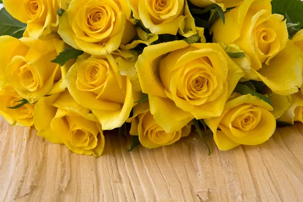Κίτρινα τριαντάφυλλα πάνω από το ξύλινο τραπέζι. — Φωτογραφία Αρχείου