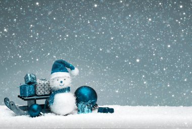 Noel Baba şapkalı ve gri arka planda izole edilmiş hediyeli Noel Kardan Adam..