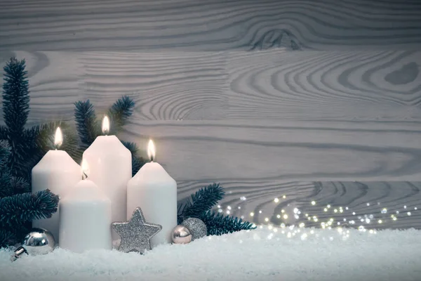 Veselé vánoční pozadí se čtyřmi bílými adventní svíčky na sněhu. — Stock fotografie