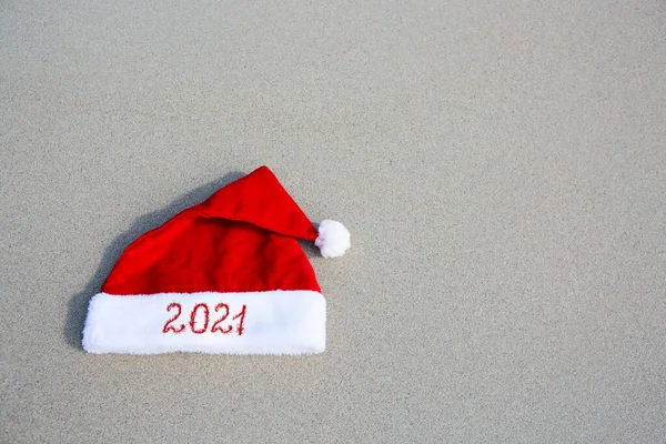 Año 2021 escrito en el sombrero de Santa Claus en la playa caribeña. —  Fotos de Stock