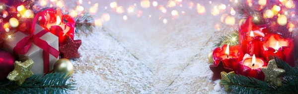 Velas rojas de Adviento con decoración navideña en la nieve. —  Fotos de Stock