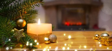 Noel arkaplanı yanan mum, şömine ve süslü Noel ağacı