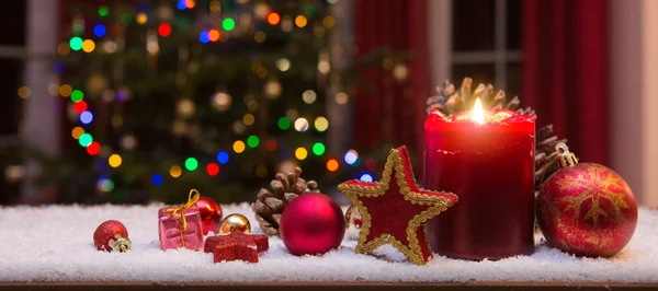 Kerst rode kaars met decoraties en dennenboom geïsoleerd op verlichting achtergrond. — Stockfoto