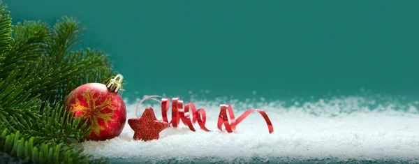 Rode Kerstbal geïsoleerd op groene achtergrond. — Stockfoto