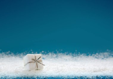 Mavi arka planda beyaz noel hediyesi izole edilmiş.