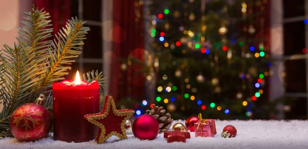 Vela vermelha de Natal com decorações e abeto isolado no fundo luzes. — Fotografia de Stock