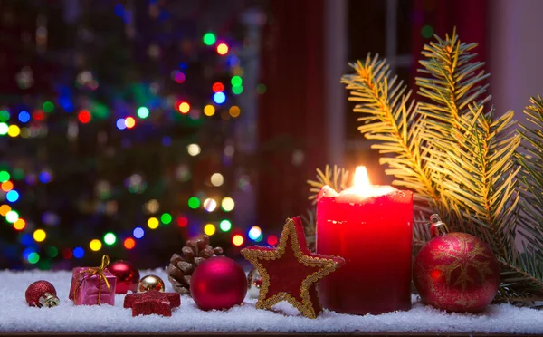 Χριστουγεννιάτικο κόκκινο κερί με διακοσμήσεις και έλατο απομονώνονται σε φώτα φόντο. — Φωτογραφία Αρχείου