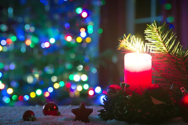 Χριστουγεννιάτικο κόκκινο κερί με διακοσμήσεις και έλατο απομονώνονται σε φώτα φόντο. — Φωτογραφία Αρχείου
