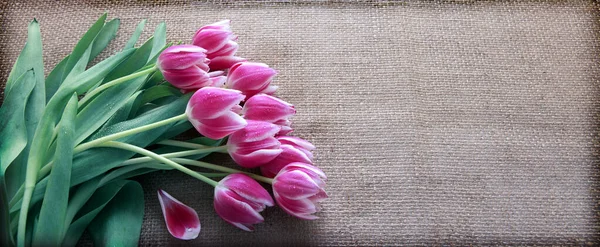 Bouquet of tulips on brown cloth Background. — Stock Photo, Image