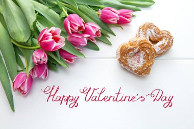 İki kalp şeklinde pasta ve bir buket lale. Sevgililer Günü kartı..