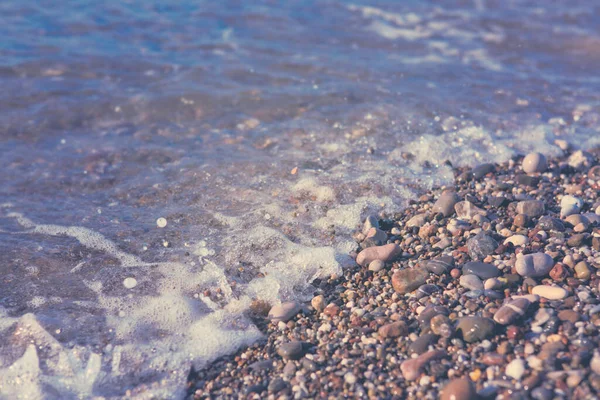 Waves washing over gravel beach, macro shot. — Stock Photo, Image