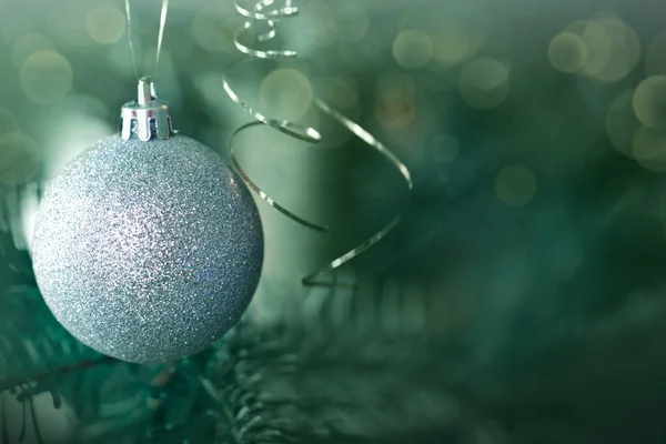 Kerst grijze bal opknoping op dennen takken met feestelijke achtergrond — Stockfoto