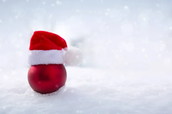 Christmas background with red santa hat on white snow. — Stock Photo, Image