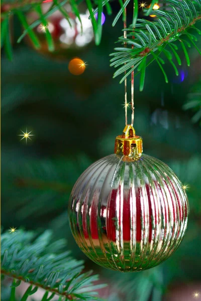 Bola amarilla de Navidad colgando en ramas de pino con fondo festivo —  Fotos de Stock