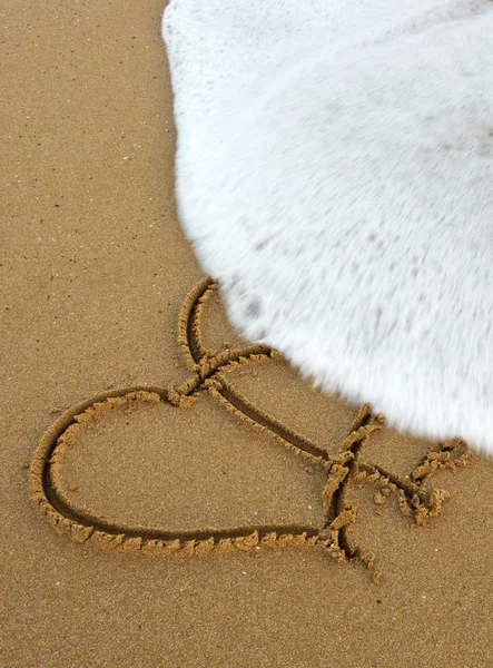 İki aşk kalbi kum üzerinde. — Stok fotoğraf