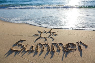 Yazın kumsalda yazılıydı. Plaj ve dalga arka planı.