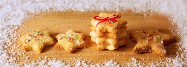 Ahşap arka plan ve kar üzerinde izole Noel kurabiyeleri.