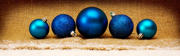 Bolas de Natal azuis isoladas no fundo de tecido marrom . — Fotografia de Stock