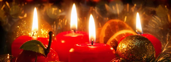 Τέσσερα κόκκινα κεριά με Χριστουγεννιάτικη Χοροεσπερίδα σε ατμοσφαιρικό φως. — Φωτογραφία Αρχείου