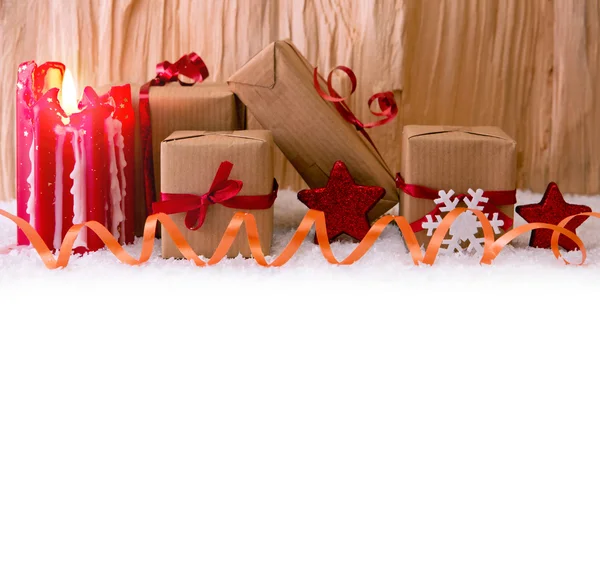 Рождественские подарки и красная свеча . — стоковое фото
