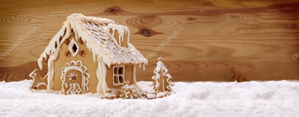 Gingerbread house isolated on wooden background.