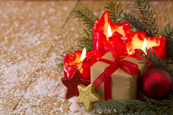 Tarjeta de Navidad. Cuatro velas rojas con regalo de Navidad . —  Fotos de Stock