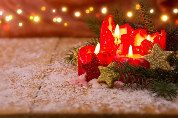 Cuatro velas rojas de Adviento con luz navideña . — Foto de Stock