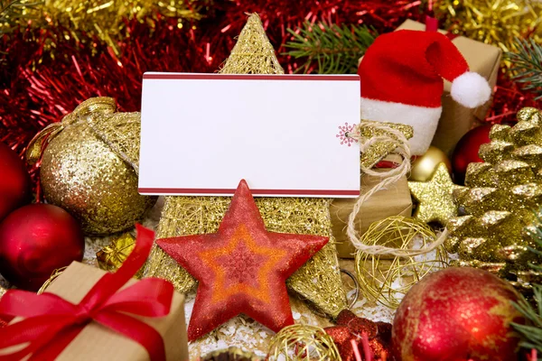 Tarjeta de Navidad en blanco con regalos, sombrero de Santa Claus y decoración . — Foto de Stock