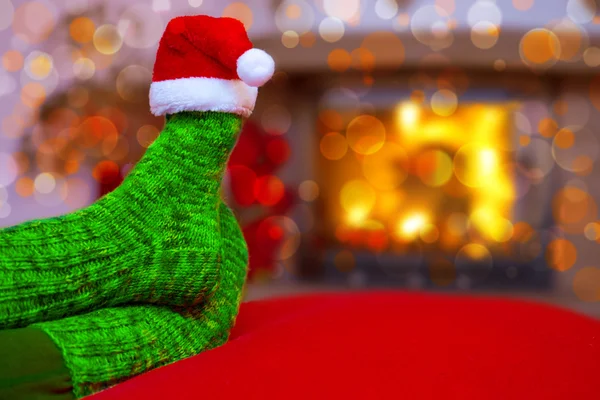 Feet in woollen blue socks and Santa hat . — Stock Photo, Image