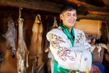 Konut, geleneksel elbiseli erkek avcısı