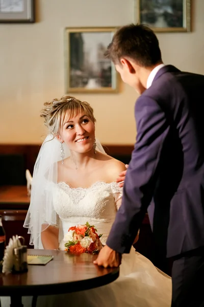 Novomanželé setkání v kavárně, líbat ženu sedící u stolu, zobrazeno úroky, návrh. — Stock fotografie