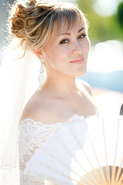 Retrato de close-up de noiva com ventilador ao ar livre ao sol . — Fotografia de Stock