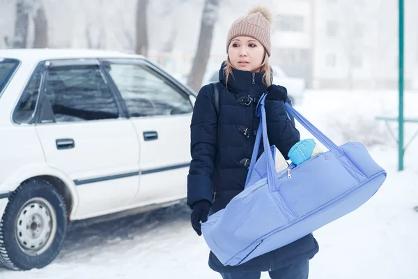 Молода мати зі своєю дитиною в сумці для колиски на відкритому повітрі взимку . Стокове Зображення