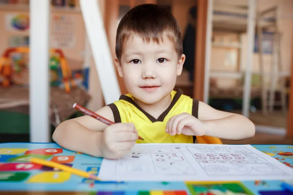 Трирічний хлопчик малює та перетворює листи . — стокове фото