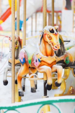 Atlı karıncaya retro atlıkarınca at kar kış city park eğlence, dikey kaplı. Terk edilmiş bir eğlence.