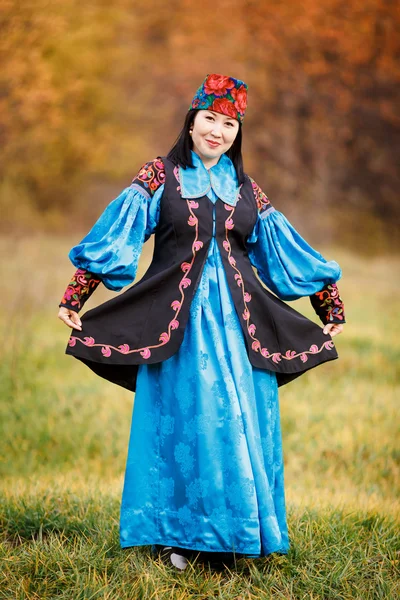 Chica hermosa alegre en vestido nacional inteligentemente azul con adornos y bordados . — Foto de Stock