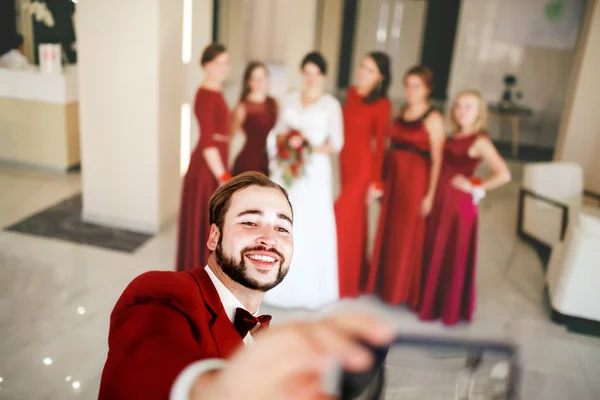 Novio hace selfie en el fondo de la novia con damas de honor foto de grupo . —  Fotos de Stock