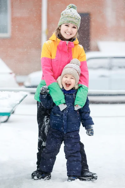 Mother with child on winter walk, positive emotions, outdoor. Snowfall, blizzard. — Stock Photo, Image