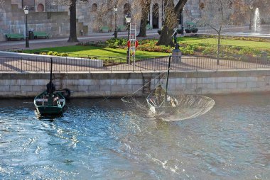 STOCKHOLM, İsveç - 25 Nisan 2016, Stockholm 'deki Lilla Vrtan Boğazı' nda bir adam tekneden balık tutuyor.