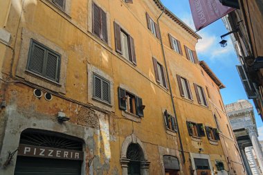 Roma, İtalya - 14 Ağustos 2019. Bir yaz günü Roma 'nın dar sokaklarındaki eski evlerin cepheleri