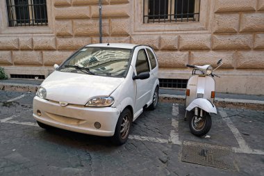 Roma, İtalya - 14 Ağustos 2019. Fiat 500 ve Vespa 'yı Roma' da bir sokağa park etti.