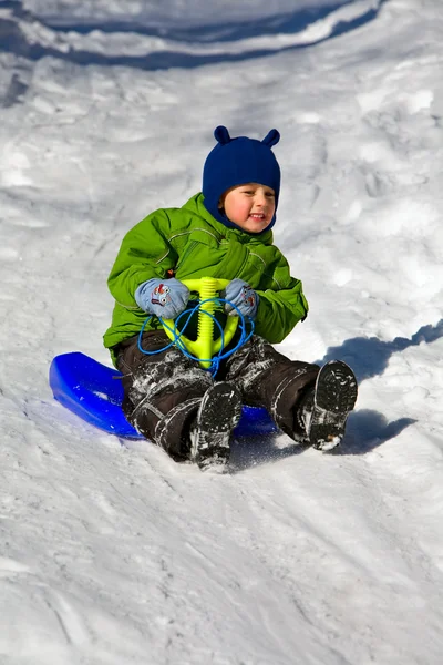Boy in green on the sledge (1) — Stock Photo, Image