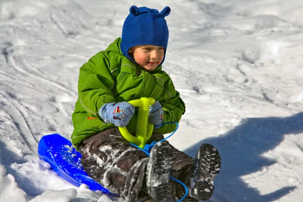 Boy in green on the sledge (3) — Stock Photo, Image