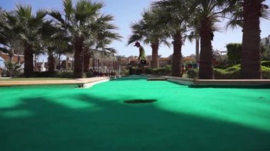 Bir çocuk mini golf oynuyor