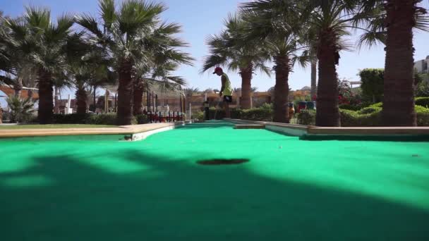 A boy plays in the mini golf — Stock Video