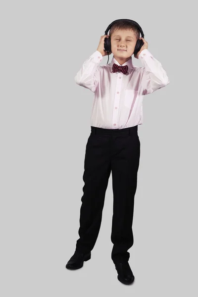 Boy in headphones with eyes closed on a gray background — Stock Photo, Image