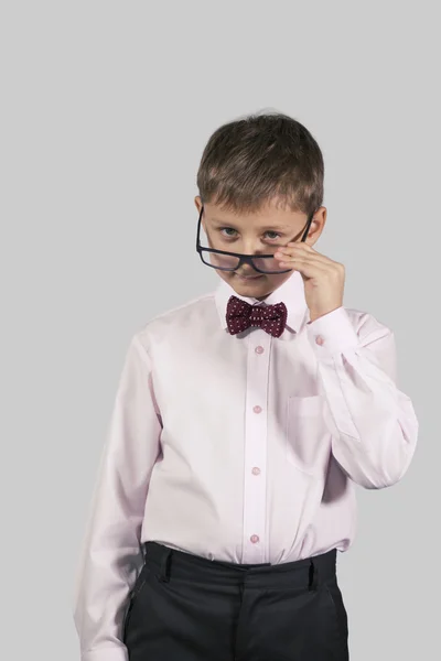 Jumătate de lungime portret al unui băiat într-o cravată de arc care se uită peste g — Fotografie, imagine de stoc